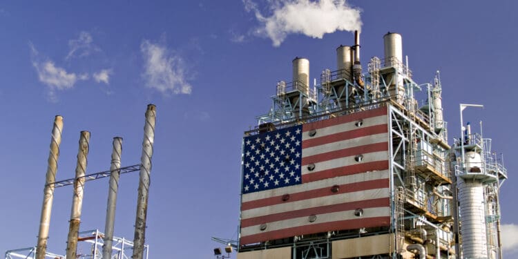 Part of oil refinery complex with big american flag displayed. Fumes coming out from the chimney.