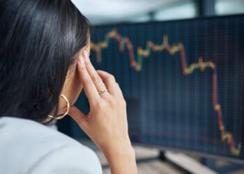 Shot of an unrecognisable businesswoman sitting in her office at night and feeling stressed while using her computer